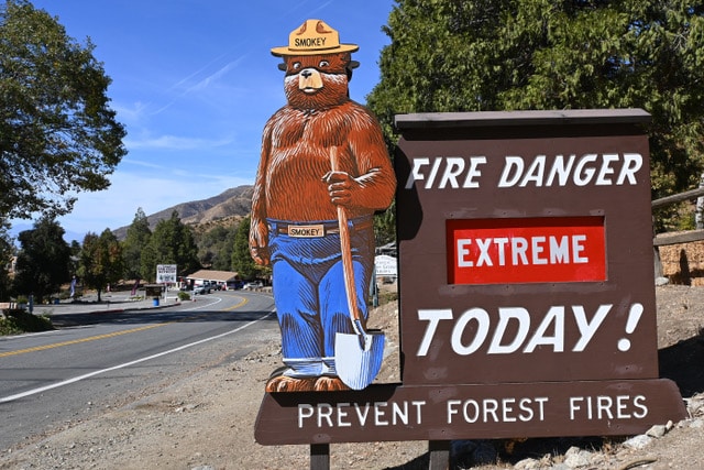 Roadside fire danger level sign with silhouette of Smokey the Bear showing fire danger level "extreme"