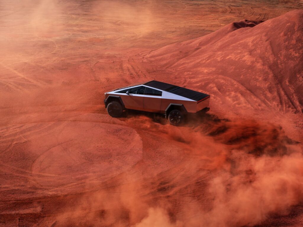 Tesla Cybertruck driving circles across red dust landscape