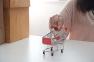 Close-up female's hand holding shopping cart, for online shopping or selling online concept.