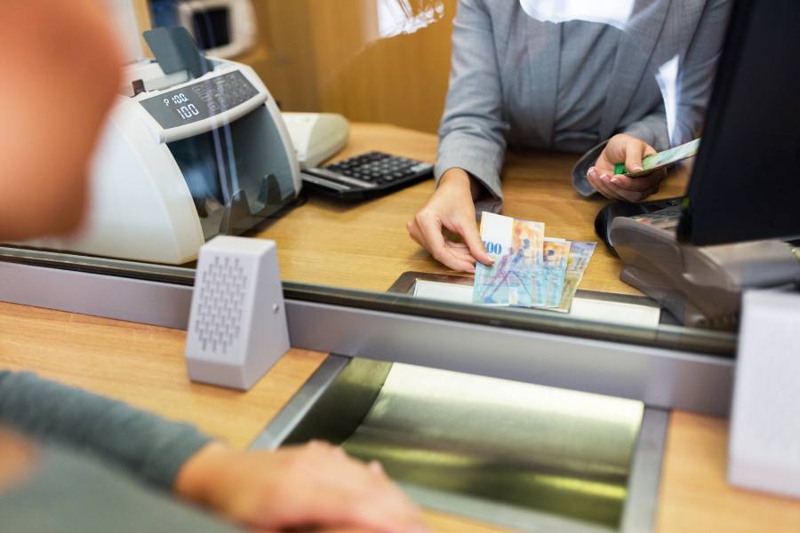 Clerk counting cash money at bank office.