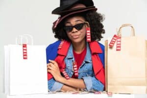 Young woman wearing hats posing with shopping bags