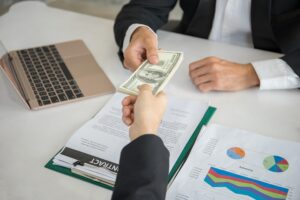 A business owner receiving money from a lender for business financing.