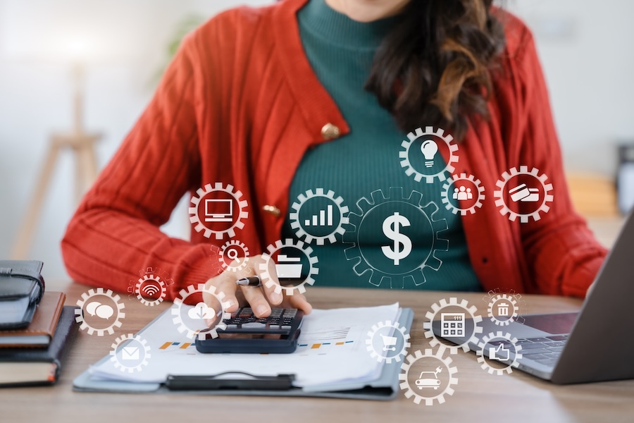 Businessperson working with holding a pen and using a calculator to calculate.