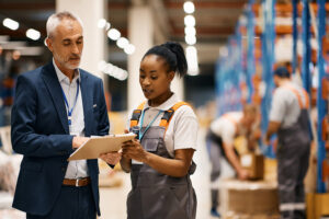 Worker and manager having a discussion at a warehouse.