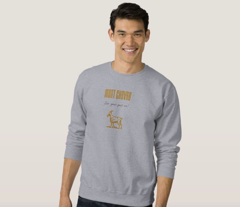 An Asian male model wearing a crew neck gray sweatshirt with a Mont Chevre Farms logo and “Get your goat on” tagline on the chest in gold print.