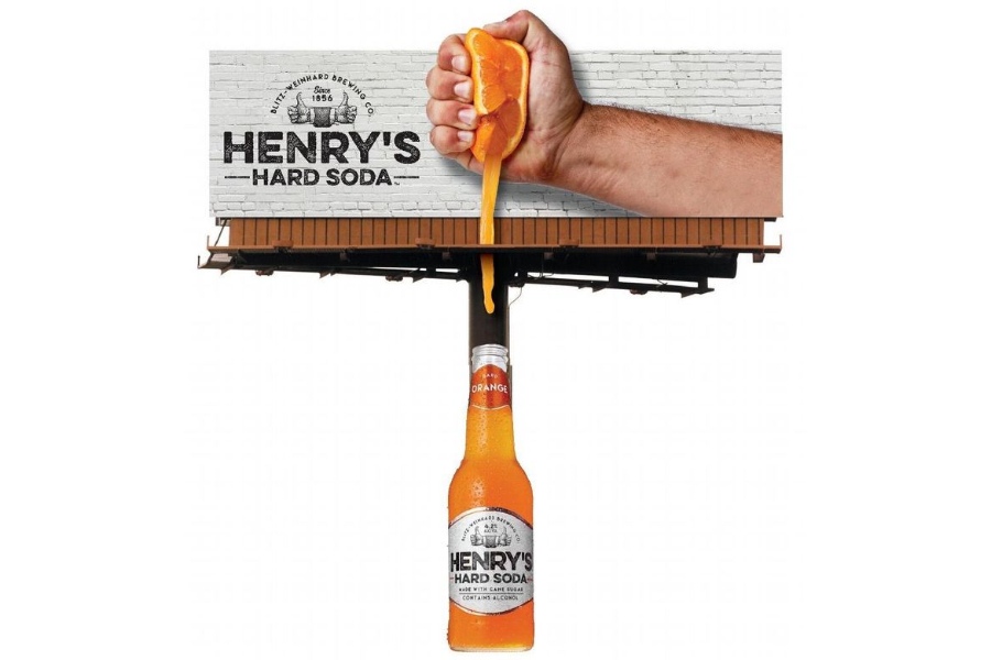 A billboard by Henry's Hard Soda incorporating the billboard pole as a soda bottle.