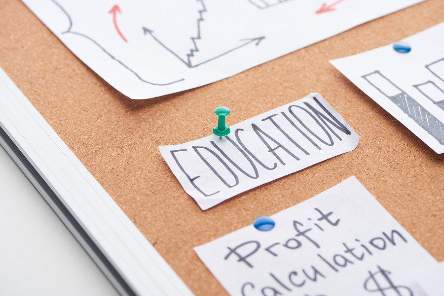 paper card with education text pinned on cork office