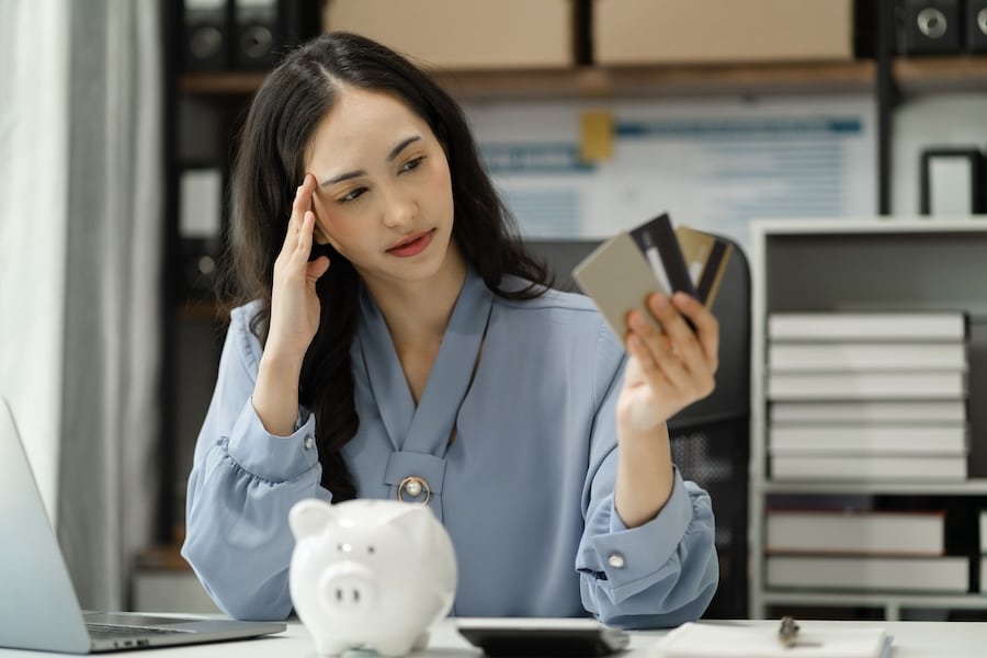 Young asian woman cover her face after stressed with credit card debt.