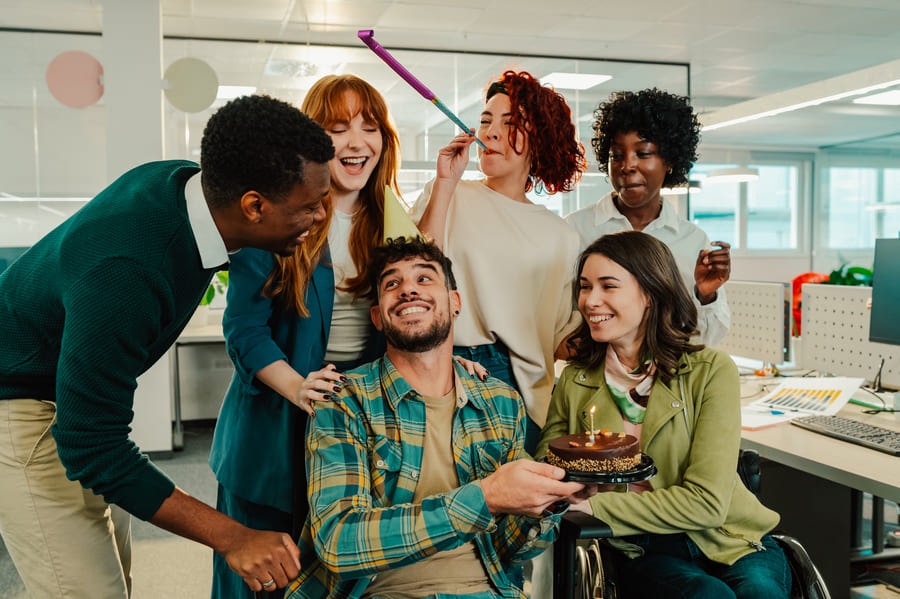 A diverse team celebrating a promotion at the office.