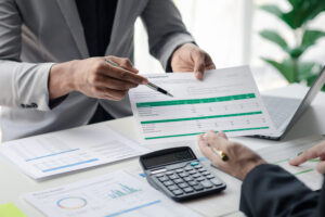 Executives and managers in a meeting in conference room, with some documents in the table.