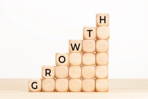 Growth concept. Text in wooden dices on table. White background. Copy space