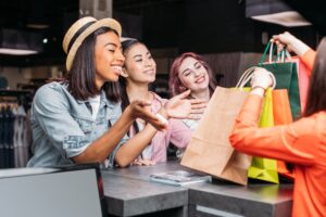 Happy young women buying clothes and looking at shopping bags, young girls shopping concept.