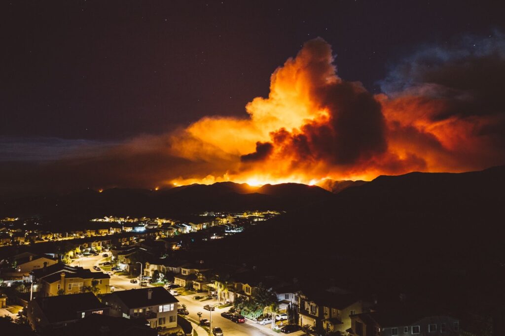 city at night with large wildfire in the background