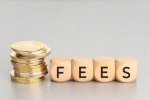 Fees wooden letters with coins stacked.