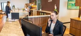 Servcorp receptionist answering phone calls at the front office desk.