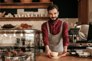 Friendly barista serving coffee in cafe
