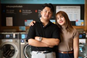A young asian couple inside a laundry shop.