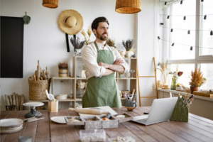 Portrait of male potter, standing in front of table with tools for sculpture.