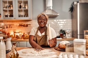 A happy woman baking on her home kitchen.