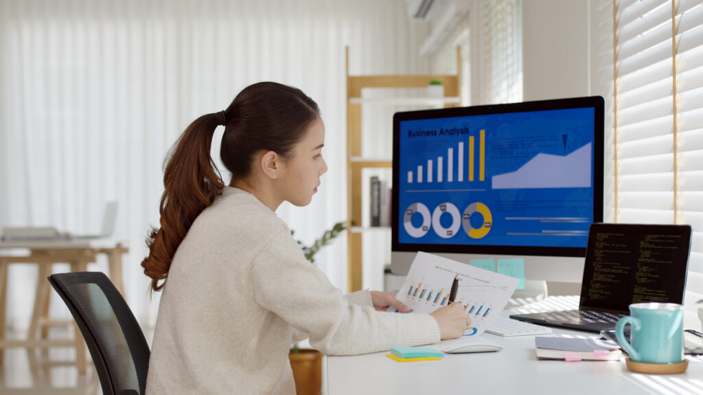 A female employee reviewing business analytics from the comforts of her home office.