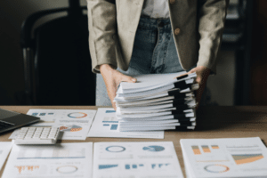 Businesswoman with many financial document to audit budget of company. tax, bill, account concept