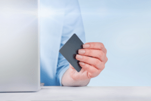 Woman or businesswoman working at laptop and holds business card in office. Design element.