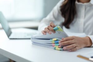 Office worker managing documents with binder clips.