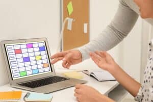 Colleagues working with calendar app on laptop in office