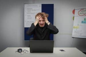 man in front of laptop frustrated