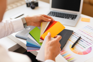 Designer Choosing Color Swatches at a White Desk